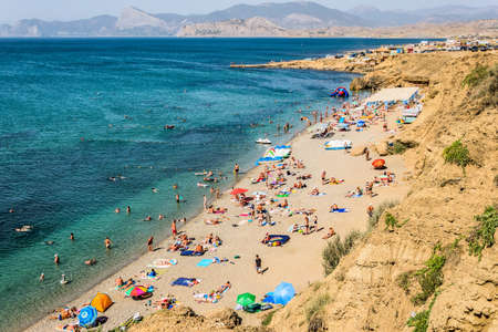 Sudak, Republic of Crimea - September 3, 2018: Beach with turquoise water in the Kapselskaya bay of the Black Sea at the foot of Cape Meganomのeditorial素材