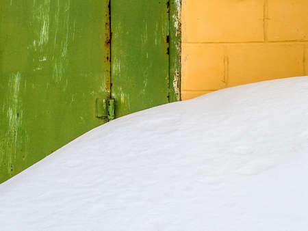 Snowdrift blocked the entrance to the garage. Old walls, rusty gates.の写真素材