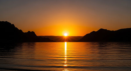 a scenic sunset over calm water with mountains in the background, a peaceful landscape viewの素材