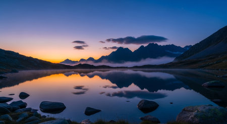 a serene mountain lake reflects the sky at sunset creating a beautiful landscape viewの素材