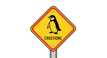 penguin crossing sign on yellow background warning about the animal crossingの素材