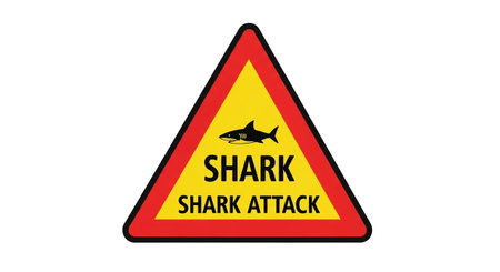 a shark attack warning sign with a shark silhouette on a yellow triangle.の素材