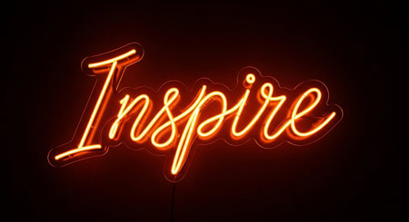a bright neon sign with the word inspire glowing orange on a dark black backgroundの素材