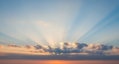 a serene sunrise with sun rays piercing through clouds, creating a heavenly sceneの素材