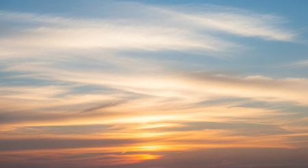 a beautiful sunset sky with soft clouds creating a serene and colorful backgroundの素材