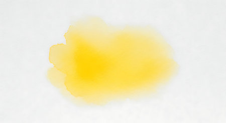 a vibrant yellow watercolor stain on a clean white background perfect for artistic creationsの素材