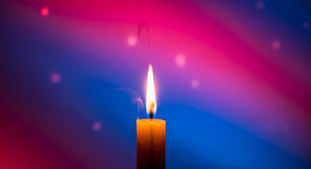 Burning candle on a colorful abstract background. Close-up.の素材