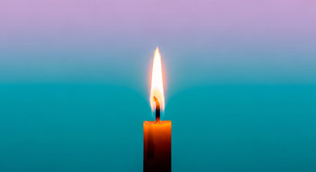 Burning candle on a blue and pink background, close-upの素材