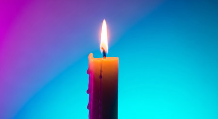 Burning candle on a blue-pink background. Shallow depth of fieldの素材