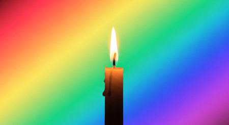 Burning candle on a multicolored background, close-upの素材