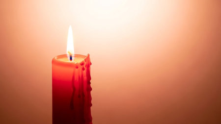 Burning red candle on a white background. Shallow depth of fieldの素材