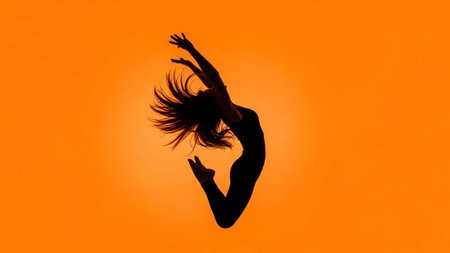 Silhouette of a woman dancing in the air on an orange backgroundの素材