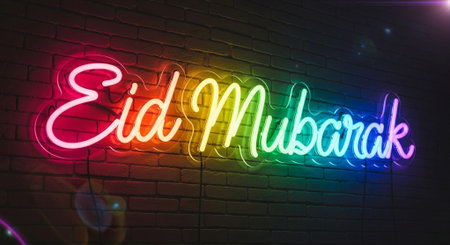 Neon sign on a brick wall with the inscription Eid Mubarak.の素材