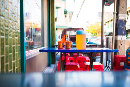 Table seat for noodle street food stall in Thailand. on the table is seasoning and teaの写真素材