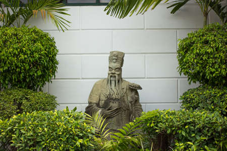 Chinese Statue behind tree, Wat Phra Chetuphon Vimolmangklararm Rajwaramahaviharn (Wat Phoの写真素材