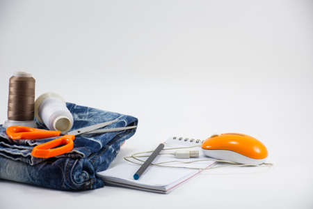 Jeans with thread and scissors and notebooks isolated. On White background.Equipment household.for designer or garment business.の写真素材
