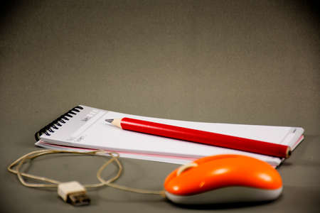 Optical mouse with note book.And pencil.On gray background. background about business plan or work...