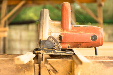 Electric saw with sawdust background in workplace of carpentry.の写真素材