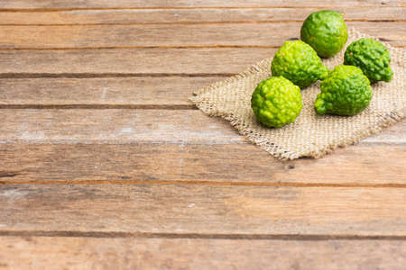 Kaffir lime on wooden table is fruits and leaves are used as a spice for thai food and etc.の写真素材