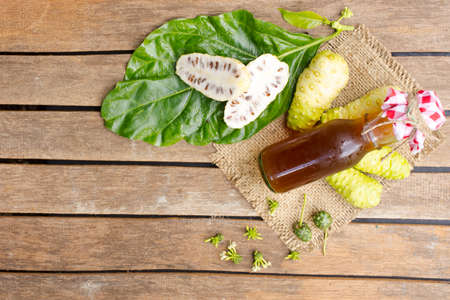 Noni fruit and noni juice on wooden table.Fruit for health and herb for health.の写真素材