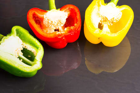 Sweet pepper green and red and yellow on black background.Ingredient of food.Close upの写真素材