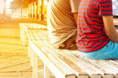 Family waiting train at train station in thailand in evening.の写真素材