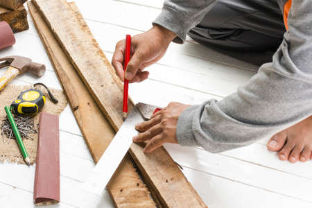 Male carpenter working with wood pencil  with machinist square at work place.Background craftsman tool.Zoom inの写真素材