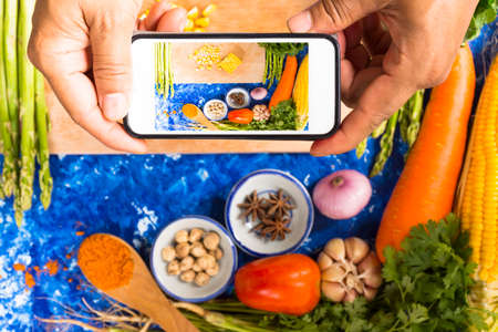 Man taking photo of vegetable with pork or raw food and ingredient on blue background dark tone.Top view.1の写真素材