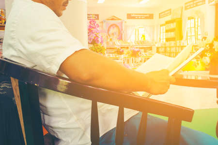 Man reading book by the window in the library.Behind the child and Zoom in.の写真素材