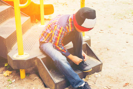 Child   tying shoes in the playground.Zoom in.