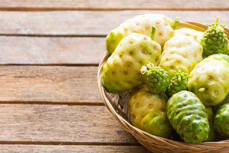 Noni fruit  in the basket on wooden table.Fruit for health and herb for health.1011の写真素材