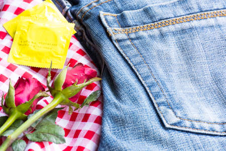 Pack condoms  with roses and jean.Sex or story valentine day.Close up