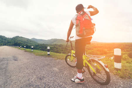 Man Asian backpack with his bike and background of nature view.の写真素材