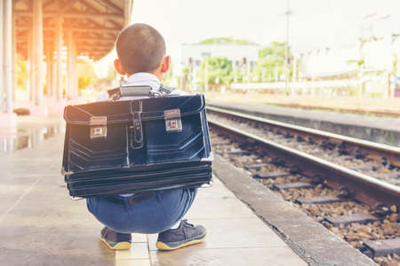 Asian boy waiting  train at train station.Back of child with sunset.1の写真素材