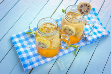 Noni herbal juice  on Blue checkered fabric and wooden background.Top view.の写真素材