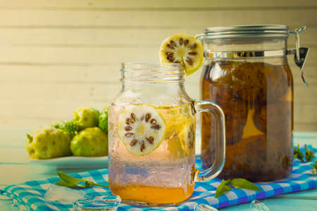 Noni herbal juice and noni fermented with dish noni fruit on Blue checkered fabricの写真素材
