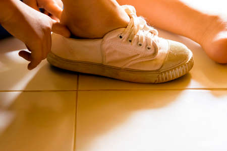 Child wearing shoe in his house.Zoom in.の写真素材