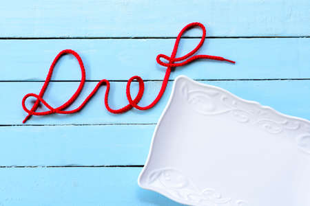 Blue background of diet concept,white dish and diet alphabet.の写真素材