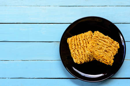 Instant noodles in black dish on blue background.の写真素材