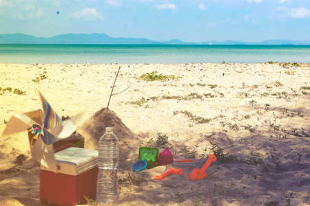 Red Ice box With a sand bucket with wind turbine and etc on the beach.の写真素材