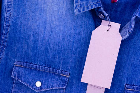 Price tag on brown shirt on jeans and close up.の写真素材