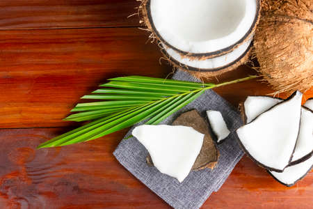 Coconut topview such as coconut half and coconut pieces and leaf  on wooden table.の写真素材