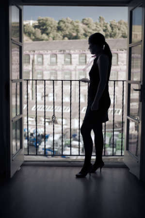 Lonely woman in front of balconyの写真素材