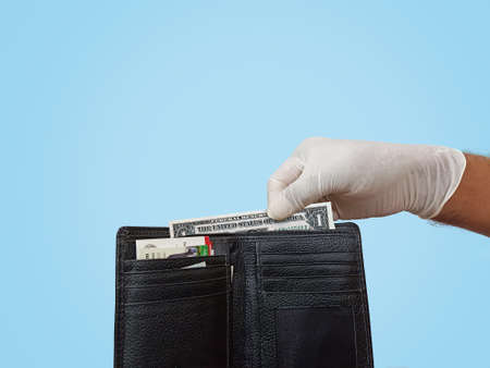 Closeup of man pick usa dollar with hands-gloves. Male hand pick money in the wallet with safe...