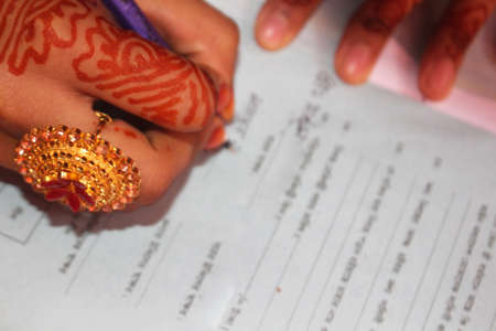 Beautiful bride signs the marriage registration documents.の写真素材