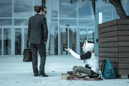 Business man is disgusted at the sight of a homeless - Caucasian people - business people, poverty and lifestyle conceptの写真素材