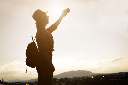 girl gets a selfie During her journey through nature - people, technology and nature conceptの写真素材