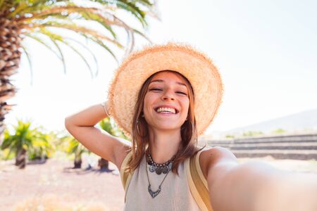 Pretty young tourist woman doing selfie on a tropical island. Concept about happiness and...