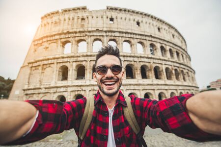 Happy tourist take a selfie in front of the Colosseum in Rome, Italy.の写真素材