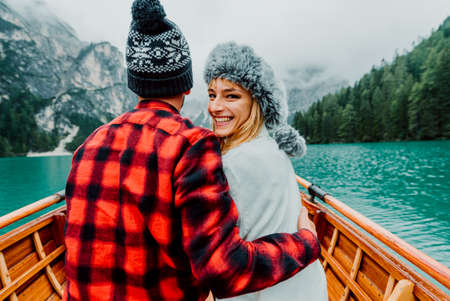 Romantic couple on a boat visiting an alpine lake at Braies Italy. Tourist in love spending loving moments together at autumn mountains. Concept about travel, couple and wanderust.の写真素材